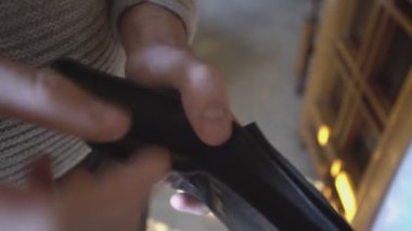 Milan, İtalya 1 Ocak 2025: Adam siyah deri cüzdanından 50 avroluk banknot alıyor