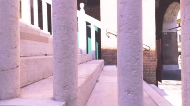 Treviso, İtalya 1 Ocak 2025: Kamera beyaz taş sütunların etrafında dönerek, mimari özellikler ve çevre binaların çeşitli açılarını ve perspektiflerini yakalıyor