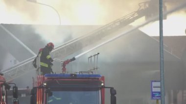 Rovigo, İtalya 1 Ocak 2025: İtfaiyeci tam teçhizatlı bir yangın hortumunu merdiven kamyonunun tepesinden kullanıyor.