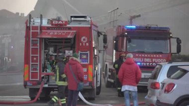Rovigo, İtalya 1 Ocak 2025: İtfaiyeciler bir ev yangınını söndürmeye hazırlanırken kamyonlarının önünde stratejilerini tartıştılar