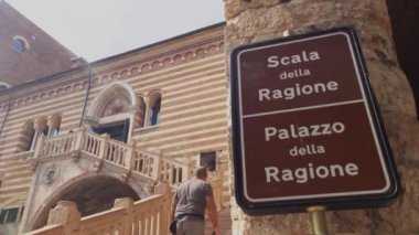 Verona, İtalya 1 Ocak 2025: Ziyaretçiler tarihi mimari ve tabelalarla çevrili Verona, İtalya 'daki Verona della ragione sarayının büyük merdivenlerini tırmanıyorlar