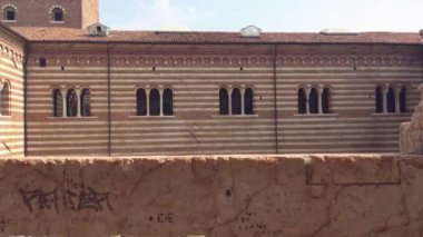 Verona, İtalya 1 Ocak 2025: Verona, İtalya 'daki tarihi bir binanın ayrıntılı cephesini araştırmak, eşsiz çizgili duvar ve kemerli camlarını sergilemek