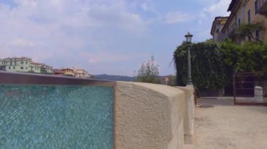 Verona, İtalya 1 Ocak 2025: Verona 'daki Adige Nehri' nin panoramik manzarası, parçalı bulutlu bir gökyüzü altında tarihi mimari ve yemyeşil ile çevrili