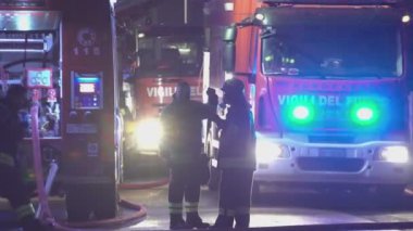 Rovigo, İtalya 1 Ocak 2025: Üniformalı itfaiyeciler ve kasklar itfaiye araçlarının önündeki durumu tartışıyor