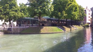 Treviso, İtalya 1 Ocak 2025: Treviso, İtalya 'da huzurlu nehir kenarı manzarası, yemyeşil yemyeşil ortamda sakin su yolu boyunca dökülen bir balıkçıyı vurguluyor