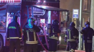 Rovigo, İtalya 1 Ocak 2025: İtfaiyeciler bir itfaiye aracının etrafında toplanarak gece çıkan yangını söndürmek için ekipmanlarını hazırlıyorlar