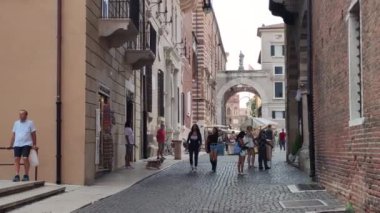 Verona, İtalya 1 Ocak 2025: Turistler ve yerliler gün içinde İtalya 'nın Verona kentinde dar bir sokakta yürüyorlar