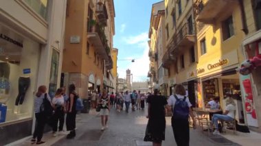 Verona, İtalya 1 Ocak 2025: Verona 'nın işlek caddesinde dükkanları ve restoranları olan turistler yürüyor