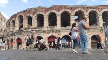 Verona, İtalya 1 Ocak 2025: İtalya 'da Verona arenası yakınlarında yürüyen turistler, Piazza bra' da büyük bir Roma amfitiyatrosu.