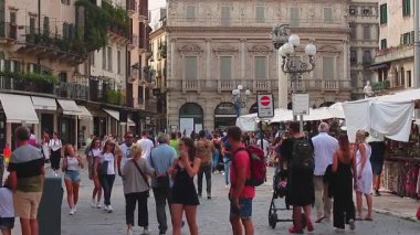 Verona, İtalya 1 Ocak 2025: Turistler ve yerliler Piazza Delle Erbe, Verona 'da günün tadını çıkarıyorlar