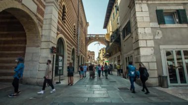 Verona, İtalya 1 Ocak 2025: Turistler ve yerliler, İtalya 'nın Verona kentindeki büyüleyici ve tarihi bir sokakta geziniyor, mimarinin ve hareketli atmosferin tadını çıkarıyorlar.