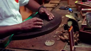 Milan, İtalya 1 Ocak 2025: Puro üreticisi atölyesindeki tütün yapraklarını yuvarlıyor ve kesiyor