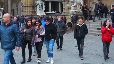 Floransa, İtalya 1 Ocak 2025: Michelangelo 'nun Davut' u ve arka planda palazzo vecchio ile birlikte Neptün Pınarı 'nın kopyasıyla Piazza della Signoria' da yürüyen turistler