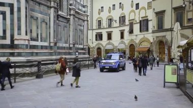 Floransa, İtalya 1 Ocak 2025: Turist ve yerel halk geçerken polis arabası yavaş yavaş Piazza San Giovanni 'den geçiyor