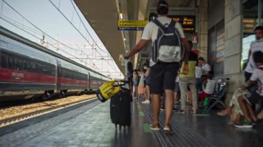 Padova, İtalya 1 Ocak 2025: Bir tren Padua, İtalya 'ya varırken turist bir tren istasyonu platformu boyunca yürüyor