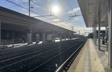 Roma, İtalya 02 Ocak 2025: Açık bir günde güneşle yıkanan boş tren istasyonu huzur ve beklenti duygusunu taşıyor.