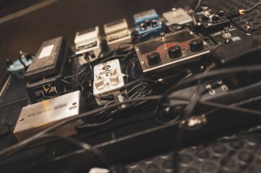 Milan, italy 4 january 2025: close-up view of a pedalboard featuring various guitar effect pedals, connected by cables and ready to shape the electric guitar's tone clipart