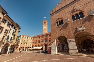 Treviso, İtalya 1 Ocak 2025: Treviso, İtalya 'da Piazza dei signori' de eğlenen turistler, Palazzo dei trecento ve belediye kulesi dimdik ayakta
