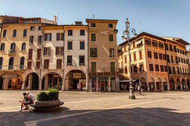 Treviso, Italy 1 January 2025: People enjoying piazza dei signori in treviso, italy, surrounded by historical buildings and shops clipart