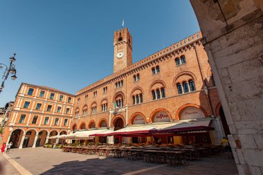 Treviso, İtalya 1 Ocak 2025: Palazzo dei trecento saat kulesiyle Treviso, İtalya 'da Piazza dei Signori' ye hükmeden açık hava restoranları