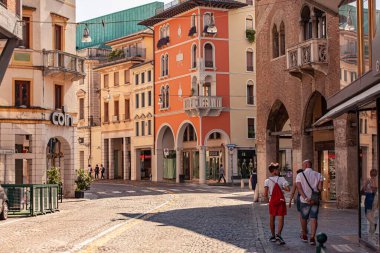 Treviso, İtalya 1 Ocak 2025: Turistler güneşli bir yaz gününde Treviso, İtalya 'nın tarihi şehir merkezinde yürüyüş yapıyorlar