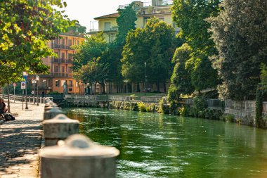 Treviso, Italy 1 January 2025: Scenic view of the cagnan river flowing through treviso, italy, showcasing the city's charm with green trees and colorful buildings lining the waterfront clipart