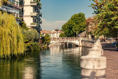 Treviso, İtalya 1 Ocak 2025: Güneşli bir yaz gününde İtalya 'nın Treviso kentinde Ponte San Martino Köprüsü' nün altından akan Cagnan Grando Nehri manzarası