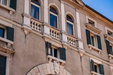 Verona, İtalya 1 Ocak 2025: Verona 'da tarihi bir binanın ön cephesi. İtalya. Kemerli pencereler. Dekoratif balkonlar. Ve yeşil kepenkler