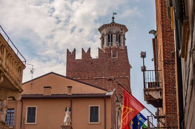 Verona, İtalya 1 Ocak 2025: Torre dei lamberti bulutlu bir gökyüzüne karşı İtalya ve Avrupa bayrakları sergiliyor