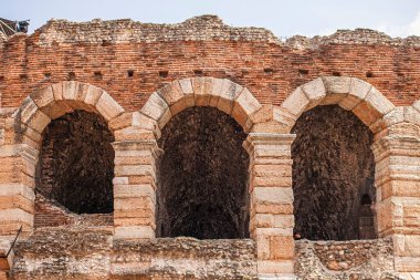 Verona, İtalya 1 Ocak 2025: Arena di Verona 'nın kemerli girişi ve tuğla duvarları, İtalya' nın Verona şehrinde antik mimarisini gösteren bir Roma amfitiyatrosu.