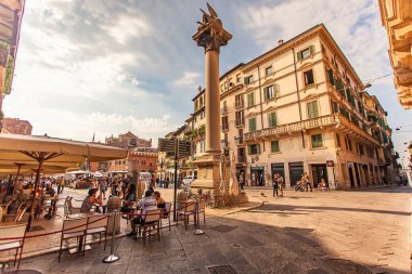 Verona, İtalya 1 Ocak 2025: Piazza delle erbe, Verona 'da bir kafede dinlenen turistler, İtalyan yazının tadını çıkarıyorlar