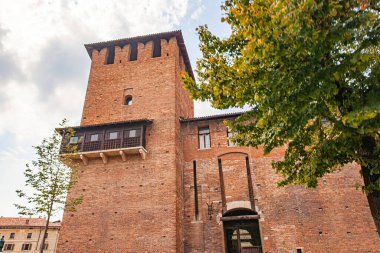 Verona, İtalya 1 Ocak 2025: İtalya 'nın Verona şehrinde bir ortaçağ şatosu olan Castelvecchio' nun alçak açılı görüntüsü tuğla kulesi ve köprüsünü sergiliyor.