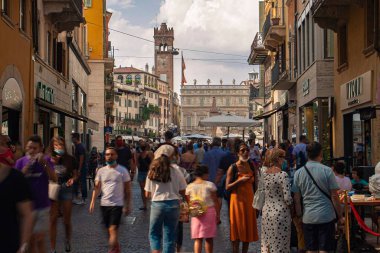 Verona, İtalya 1 Ocak 2025: İnsanlar mazzini üzerinden yürüyen yüz maskeleri takıyor, İtalya 'nın tarihi merkezi Verona' da yaya bir alışveriş caddesi.