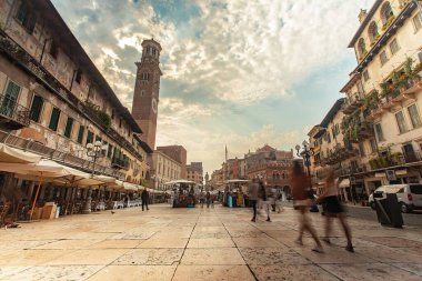 Verona, İtalya 1 Ocak 2025: İtalya 'da Torre dei Lamberti ile Piazza delle erbe' de yürüyen turistler