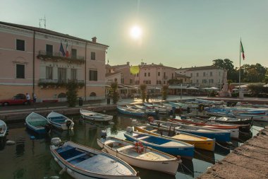 Garda Gölü, İtalya 3 Ocak 2025: Güzel bir günbatımında İtalya 'nın Garda gölündeki Bardolino limanında demirli küçük renkli tekneler