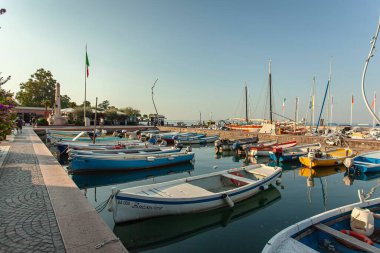 Garda Gölü, İtalya 3 Ocak 2025: Bardolino 'da Garda Gölü' nde sakin sularda sallanan renkli tekneler huzurlu ve huzurlu bir manzara yaratıyor.