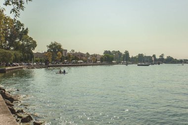 Garda Gölü, İtalya 3 Ocak 2025: İtalya 'da popüler bir tatil beldesi olan Bardolino ve Lazise kentleri ile birlikte Garda Gölü' nde kayak yapan iki turist, İtalya 'nın en popüler tatil beldesi olan kıyı şeridinde görülüyor.