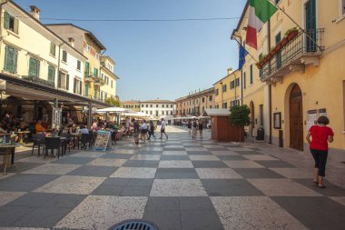 Garda Gölü, İtalya 3 Ocak 2025: İnsanlar, Garda Gölü 'nün güneydoğu kıyısındaki bir kasaba olan tembel bir meydanda güneşli bir günün tadını çıkarıyor