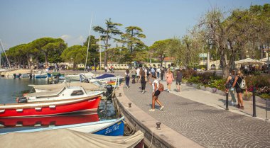 Garda Gölü, İtalya 3 Ocak 2025: Turistler Bardolino 'daki Garda Gölü kıyılarında güneşli bir günün tadını çıkarıyorlar.