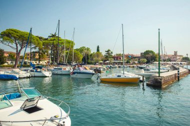 Garda Gölü, İtalya 3 Ocak 2025: Yelkenliler ve motorbotlar İtalya 'nın Garda gölündeki turistik Bardolino limanına yanaşıyor