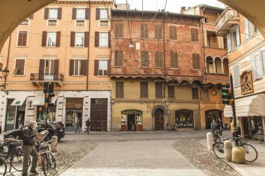 Modena, İtalya 1 Ocak 2025: Modena 'daki geleneksel İtalyan sokak sahnesi, renkli binalar, kaldırımlar ve gündelik yaşamlarını sürdüren yerliler