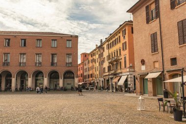 Modena, İtalya 1 Ocak 2025: Modena, İtalya 'da meydanda yürüyen turistler, renkli binaların ve kaldırım taşı meydanının keyfini çıkarıyorlar.