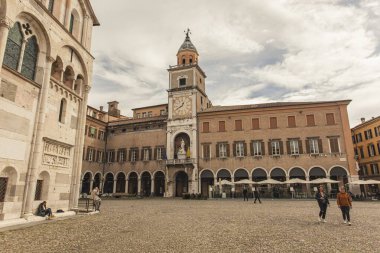 Modena, İtalya 1 Ocak 2025: Bulutlu bir günde, arka planda duomo ve saray komünü ile büyük meydanda yürüyen turistler
