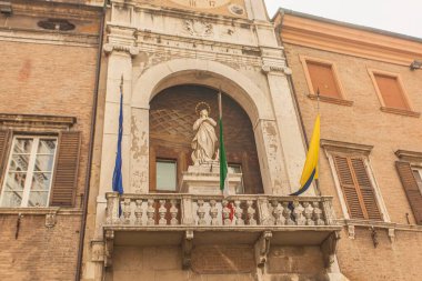 Modena, İtalya 1 Ocak 2025: Modena, İtalya 'daki tarihi saray (belediye binası) cephesini süsleyen beyaz mermer bir haleli Meryem heykeli