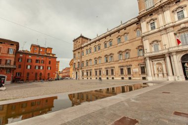 Modena, İtalya 1 Ocak 2025: Ducal Palace bulutlu bir günde Roma Meydanı 'ndaki bir su birikintisine yansıyor