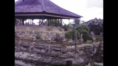 Denpasar, Bali Haziran 1985: Bali 'de tarihi bir tapınak kompleksini keşfeden turistler, 1985 yılında geleneksel bale mimarisi ve kültür mirasını sergilediler.