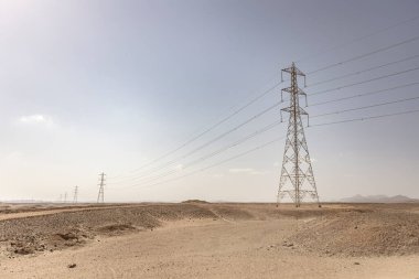 Elektrik direkleri Mısır 'daki Marsa Alam Çölü' nün kurak arazisinde enerji taşıyorlar.