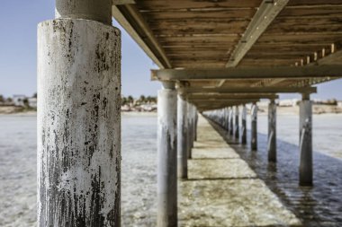 Güneşli bir günde, Marsa alam, Mısır 'da, sığ sulara uzanan beton sütunlu ahşap iskele.