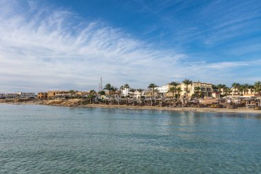 Sakin kızıl deniz suları Marsa alam plaj tatil beldesinin kumlu sahillerine usulca sarılarak berrak Mısır gökyüzünün altında rahatlama ve sükunet vaat ediyor.