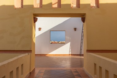 Güneş ışığı, Marsa Alam, Mısır 'daki bir pencereden deniz manzaralı fayanslı bir avluda dramatik gölgeler bırakır.